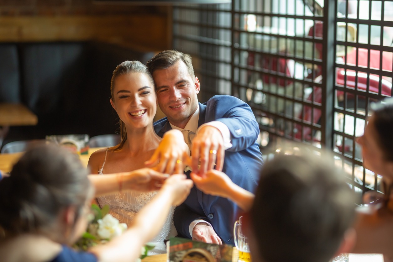 pareja de novios muestra a sus colegas los anillos de compromiso